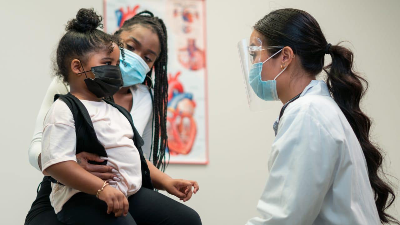 Parent and child speak with their doctor.