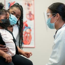 Parent and child speak with their doctor.