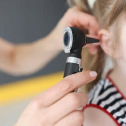 Doctor examines ear of young girl.