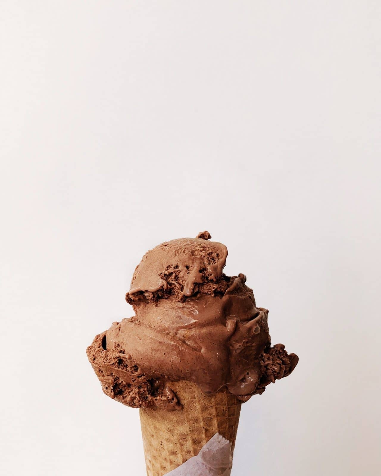 A scoop of chocolate ice cream on a cone.