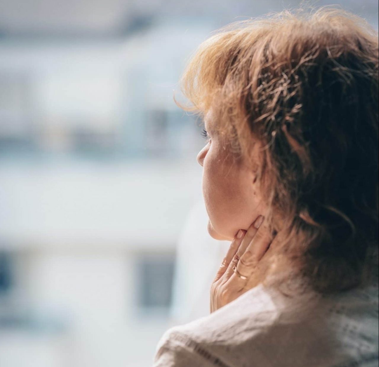 Woman feeling her neck.