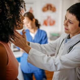 Doctor examining patient with a sore throat.