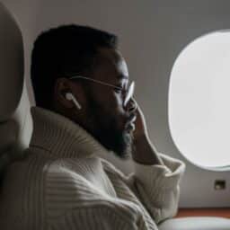 Man sitting in the window seat while flying.