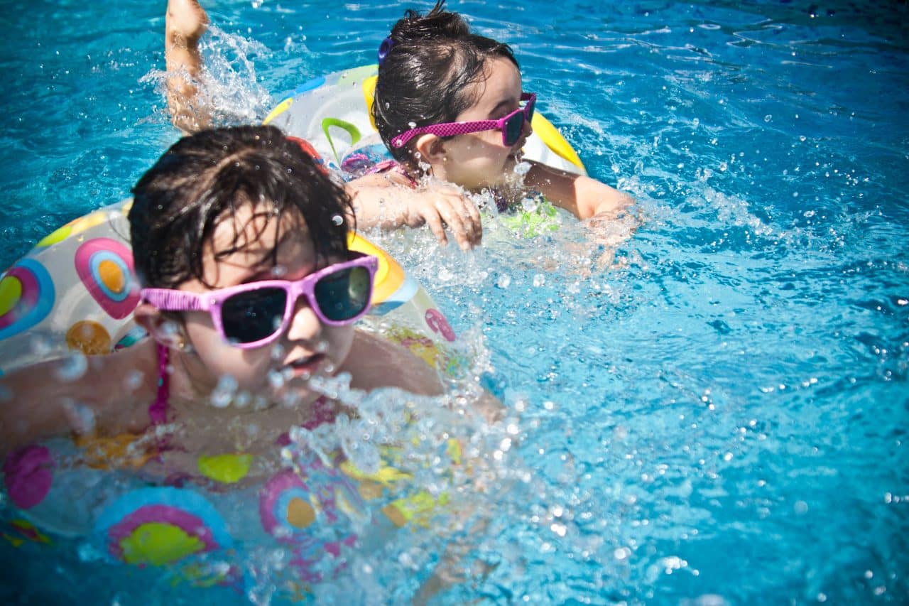 Two little girls swimming in a pool.