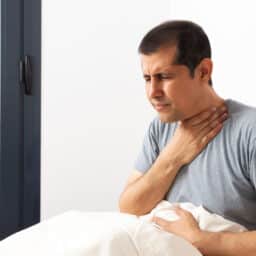 Man waking up with a sore throat.