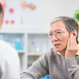 Man explaining ear pain to his ENT specialist