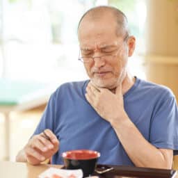 Man having trouble swallowing his coffee