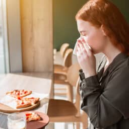 Woman blowing nose during dinner