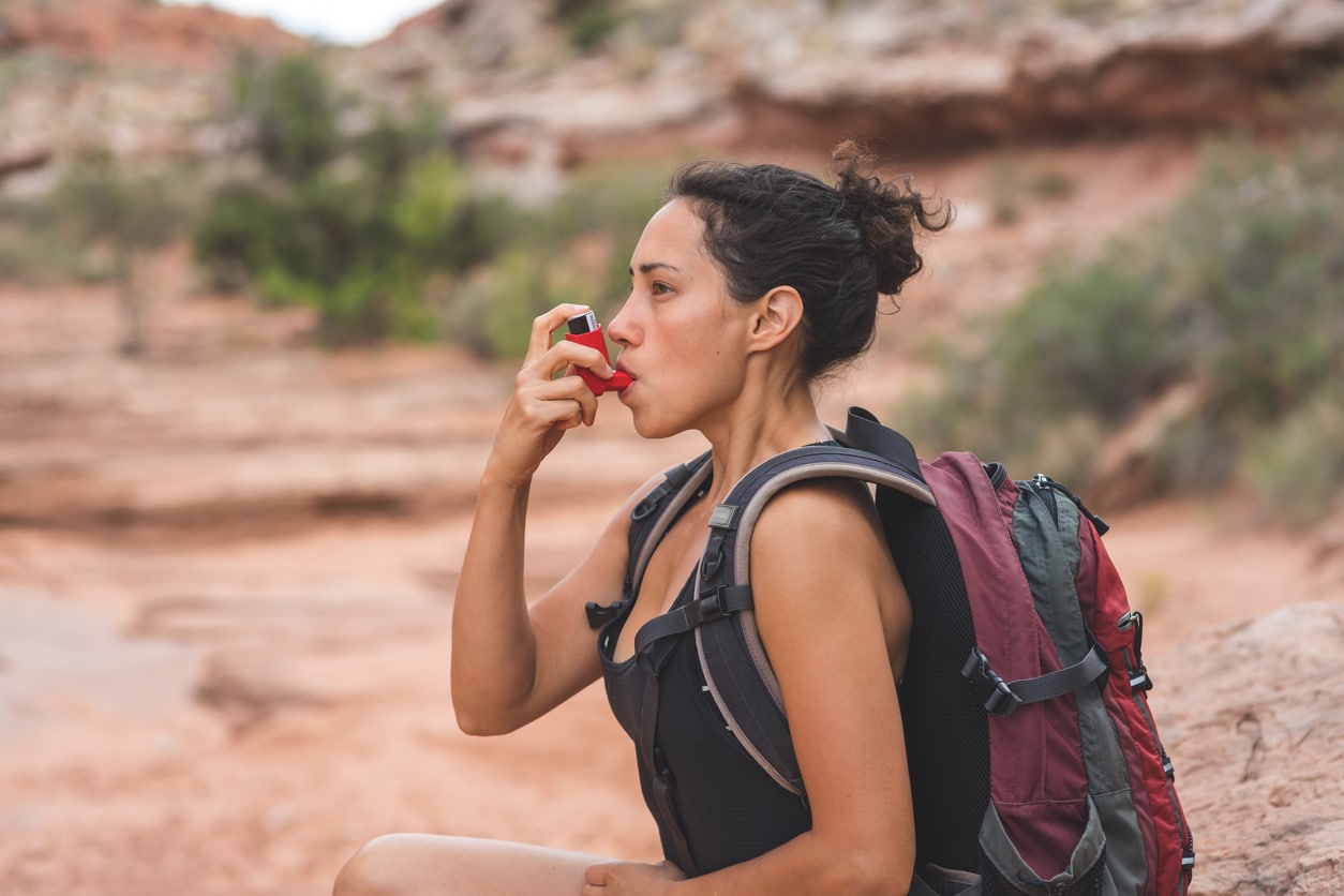 Woman uses inhaler on hike