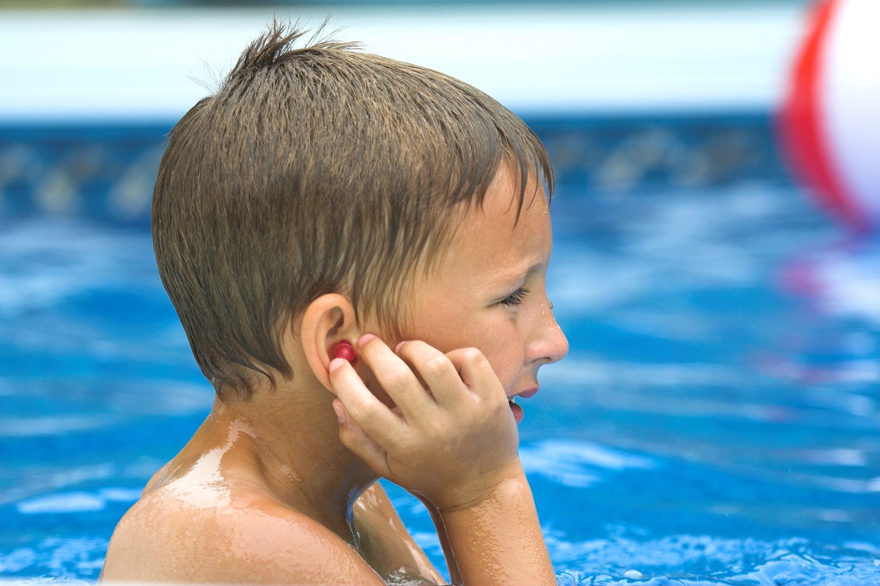 Boy holds earplugs