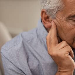 Man with ear pressure holds ear