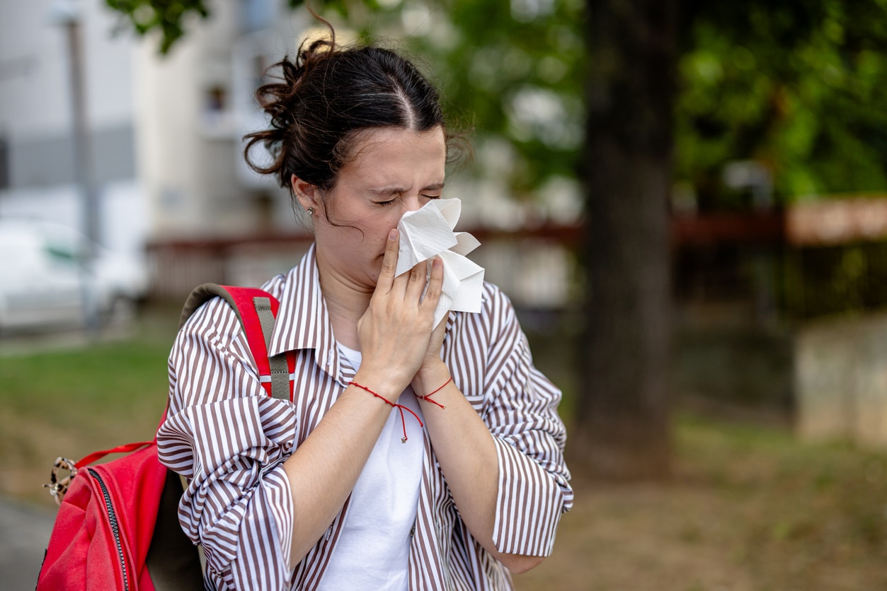 Woman outside blowing her nose