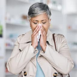 Woman blowing her nose into a tissue