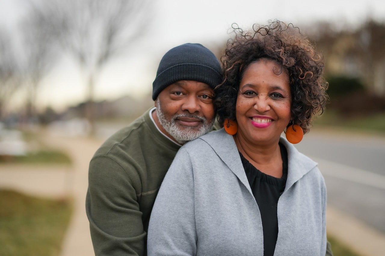 older smiling couple standing on sidewalk