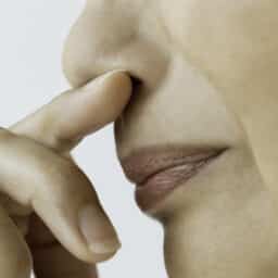 Woman holding her finger to her nose