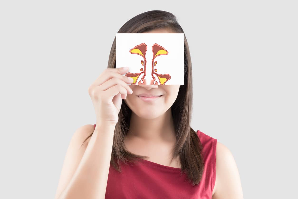 Woman holding up a card with a sinus illustration on it.