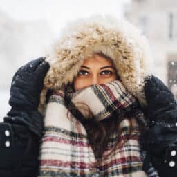 Woman all bundled up standing in the snow