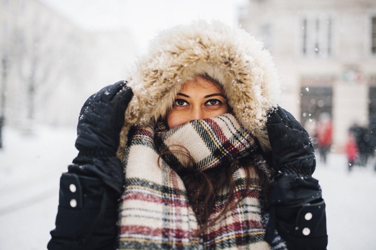 Woman all bundled up standing in the snow.