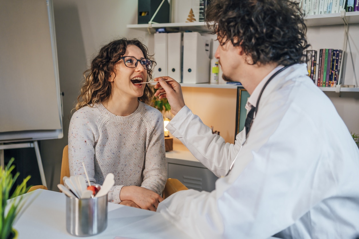 ENT examining a woman's throat.
