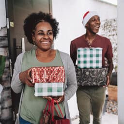 Two people carrying wrapped presents.