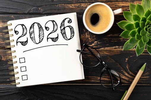New year resolutions 2026 on desk. 2026 goals list with notebook, coffee cup, plant on wooden table. Resolutions, plan, goals, action, checklist, idea concept. New Year 2026 resolutions.